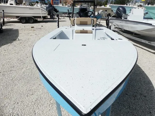 Slide: The Image of 2025 Xpress Boats Skiff 185, white deck, blue hull, parked on gravel lot. - 12