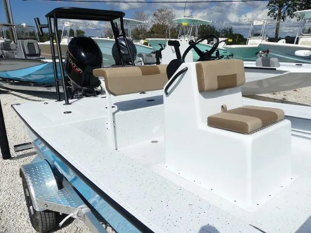 Slide: The Image of 2025 Xpress Boats Skiff 185 with beige seating, displayed outdoors on a trailer. - 13