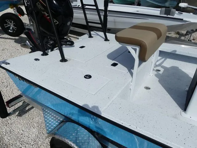 Slide: The Image of 2025 Xpress Boats Skiff 185, white deck, beige seat, outboard motor, on trailer. - 14