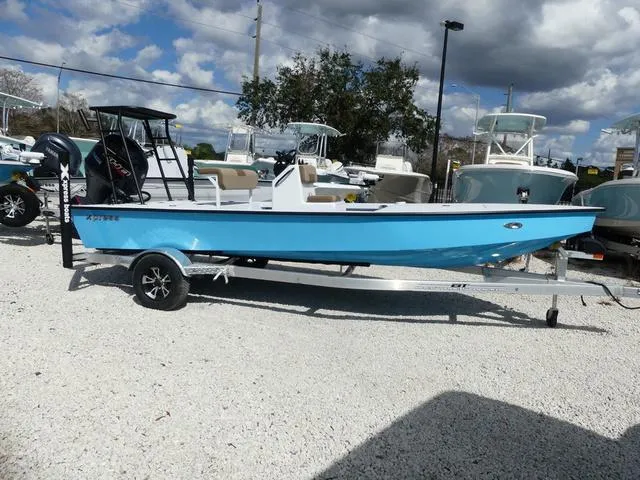 Slide: The Image of 2025 Xpress Boats Skiff 185 in blue, parked on a trailer in a boatyard. - 4