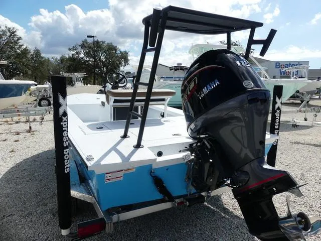 Slide: The Image of 2025 Xpress Boats Skiff 185 with Yamaha outboard motor, parked on gravel. - 7
