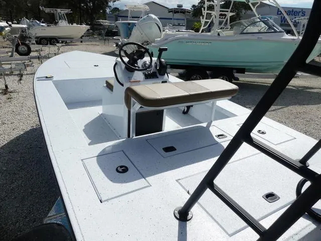 Slide: The Image of 2025 Xpress Boats Skiff 185, white deck, center console, parked on gravel lot. - 8