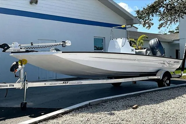 Slide: The Image of 2025 Xpress Boats H210 BAY on trailer, parked outside a building. - 1