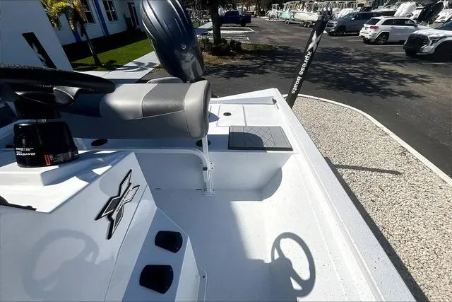 Slide: The Image of 2025 Xpress Boats H210 BAY interior with steering wheel and seating, parked outdoors. - 15