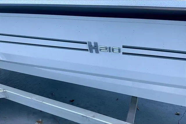 Slide: The Image of 2025 Xpress Boats H210 BAY side view with logo detail. - 16