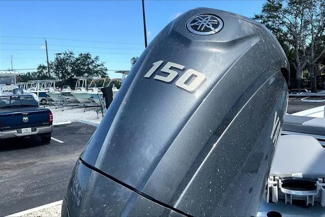 Slide: The Image of 2025 Xpress Boats H210 BAY with Yamaha 150 outboard motor in a parking lot. - 18
