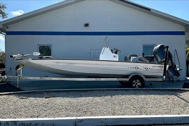 Slide: The Image of 2025 Xpress Boats H210 BAY, white, parked in front of a building. - 3