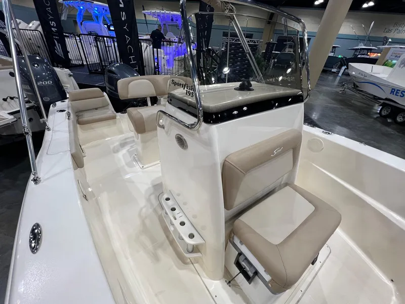 Slide: The Image of 2025 Scout 195 Sportfish boat interior with beige seating and console at a boat show. - 5