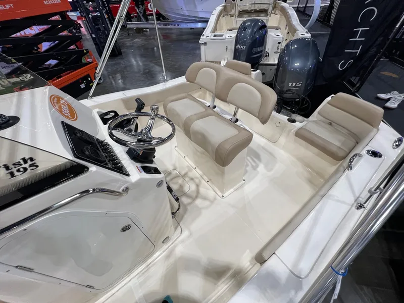 Slide: The Image of 2025 Scout 195 Sportfish boat interior with seating and dual engines displayed at a show. - 7