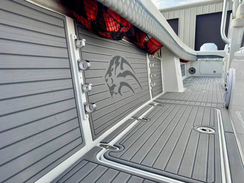 Slide: The Image of 2021 Prowler 31 boat deck with sleek gray flooring and storage compartments. - 15