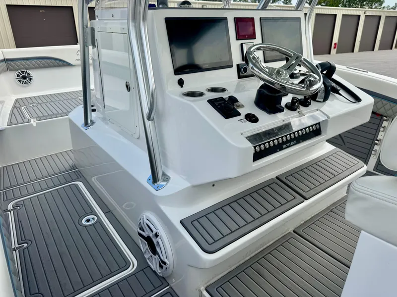 Slide: The Image of 2021 Prowler 31 boat console with steering wheel and navigation screens. - 31