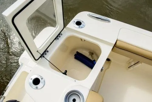 Slide: The Image of 2025 Scout 215 XSF boat storage compartment with open hatch and cup holders. - 11