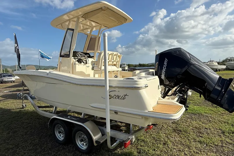 Slide: The Image of 2026 Scout 215 XSF boat on trailer with Mercury outboard motor, parked outdoors. - 4