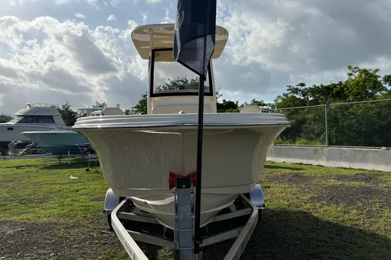 Slide: The Image of 2026 Scout 215 XSF boat on trailer, parked outdoors under cloudy sky. - 5