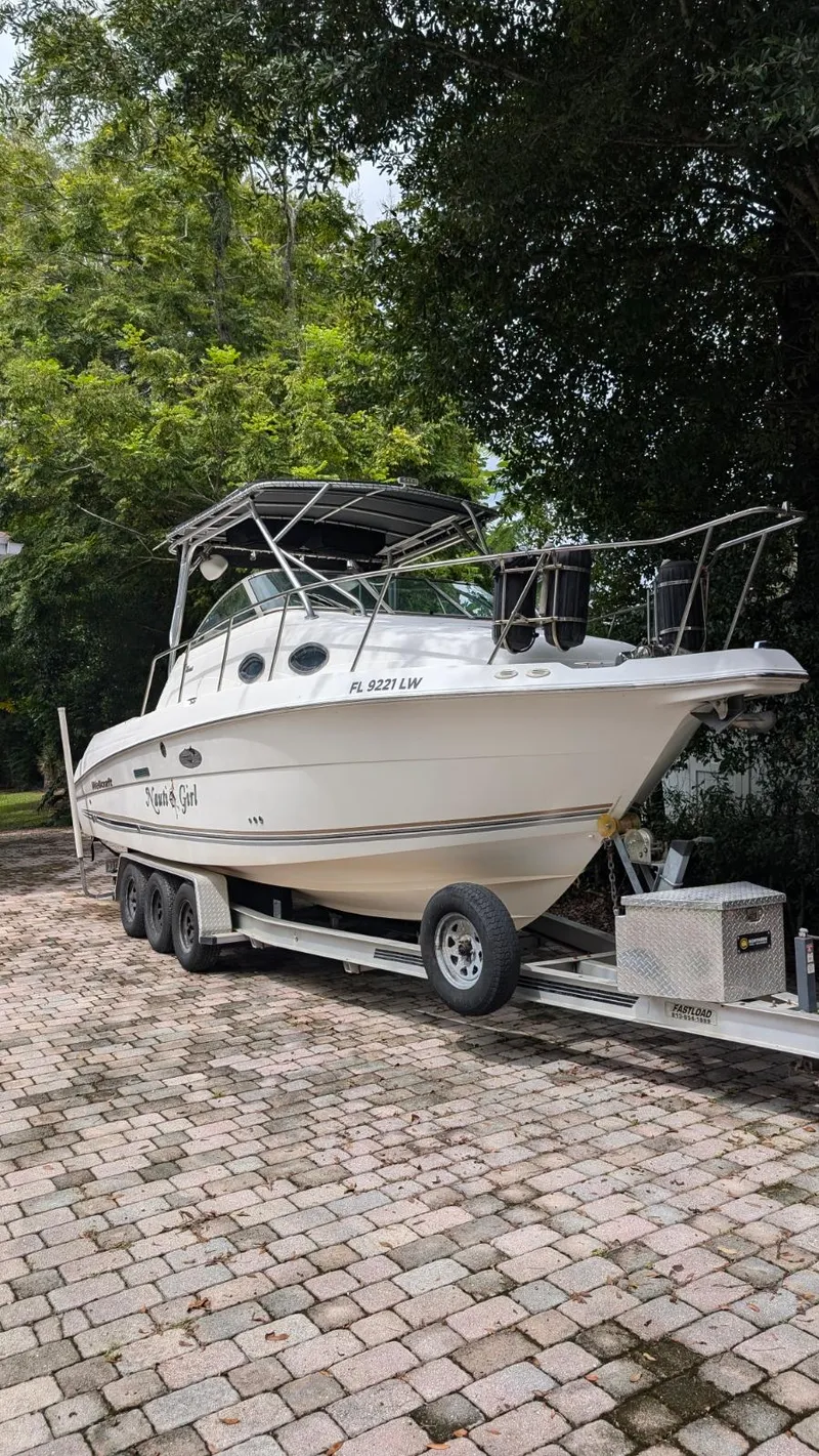 Slide: The Image of 2001 Wellcraft 270 Coastal O/B boat on trailer, parked on a cobblestone driveway. - 3