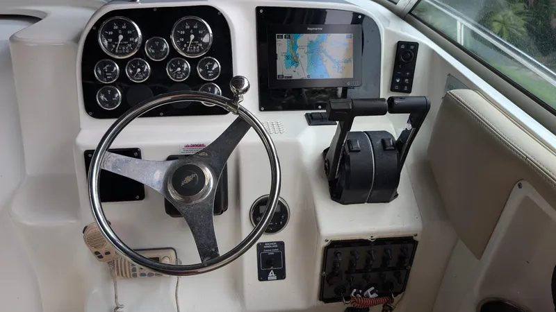 Slide: The Image of 2001 Wellcraft 270 Coastal O/B boat dashboard with steering wheel and navigation controls. - 5