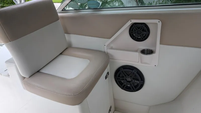 Slide: The Image of 2001 Wellcraft 270 Coastal O/B interior with beige seating and built-in speakers. - 9