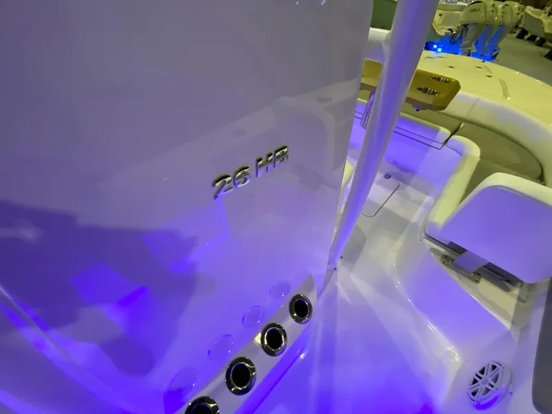 Slide: The Image of 2025 Caymas 26 HB boat interior with blue lighting and seating area. - 8