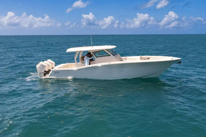 Slide: The Image of 2024 Scout 377 LXF boat cruising on open ocean under clear blue sky. - 13