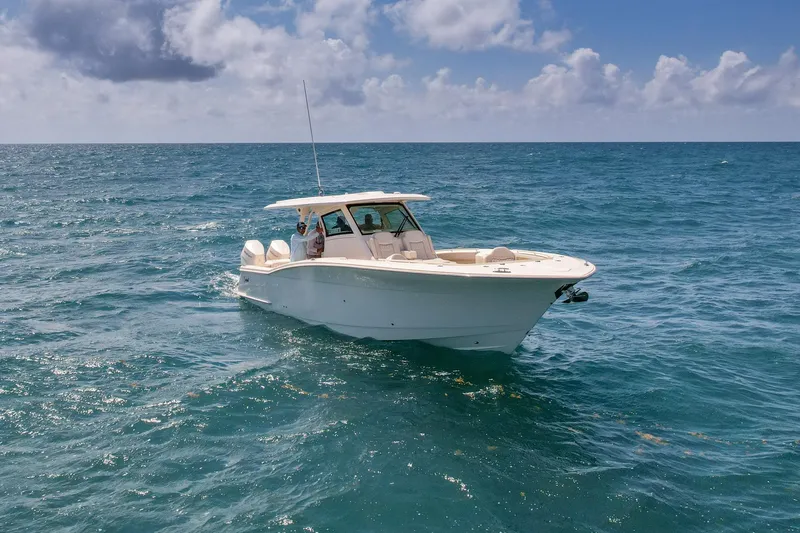 Slide: The Image of 2024 Scout 377 LXF boat cruising on open ocean under cloudy sky. - 14