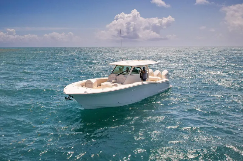 Slide: The Image of 2024 Scout 377 LXF boat cruising on open ocean under clear skies. - 15