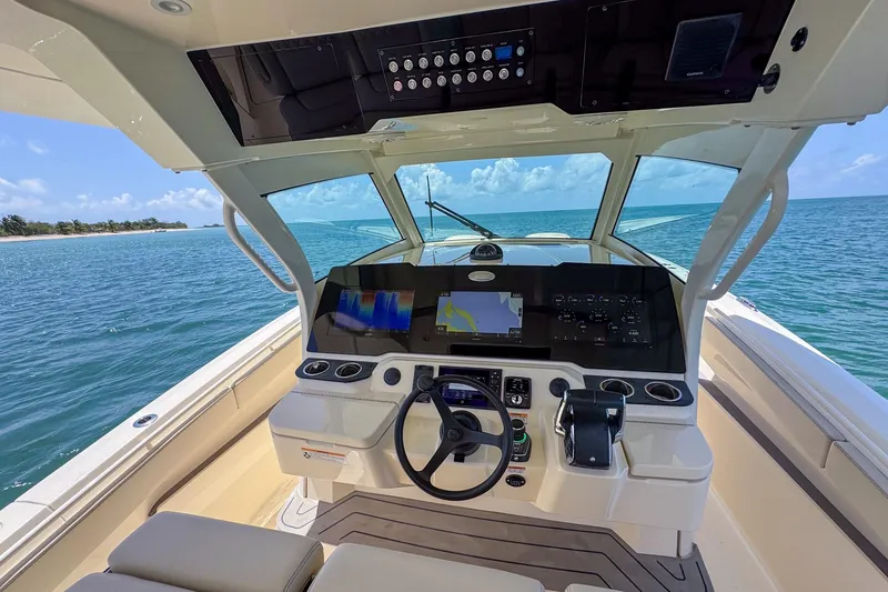 Slide: The Image of 2024 Scout 377 LXF boat cockpit with advanced navigation system on open water. - 18
