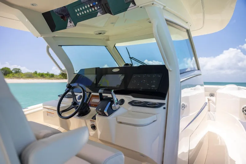 Slide: The Image of 2024 Scout 377 LXF boat cockpit with modern controls and ocean view. - 19