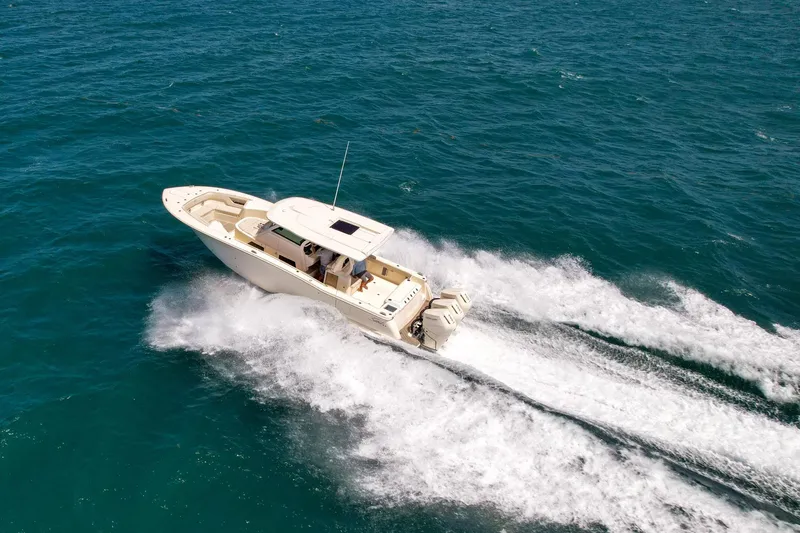 Slide: The Image of 2024 Scout 377 LXF boat cruising on open water, creating a dynamic wake. - 2