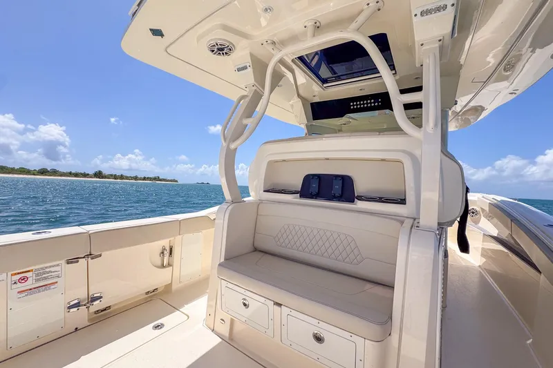 Slide: The Image of 2024 Scout 377 LXF boat interior with seating, ocean view, and clear sky. - 23