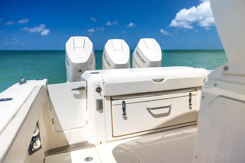 Slide: The Image of 2024 Scout 377 LXF boat with triple Mercury engines on a sunny ocean backdrop. - 25