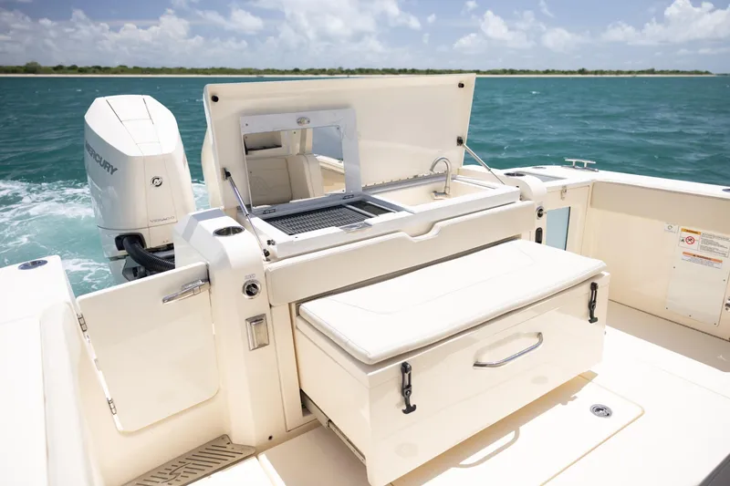 Slide: The Image of 2024 Scout 377 LXF boat with outdoor kitchen and Mercury engine on open water. - 27