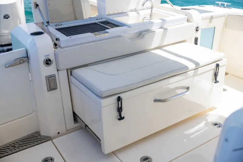 Slide: The Image of 2024 Scout 377 LXF boat interior with cushioned seating and storage compartment. - 28