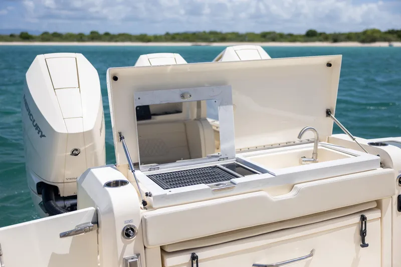 Slide: The Image of 2024 Scout 377 LXF boat with outdoor kitchen and dual Mercury engines. - 29