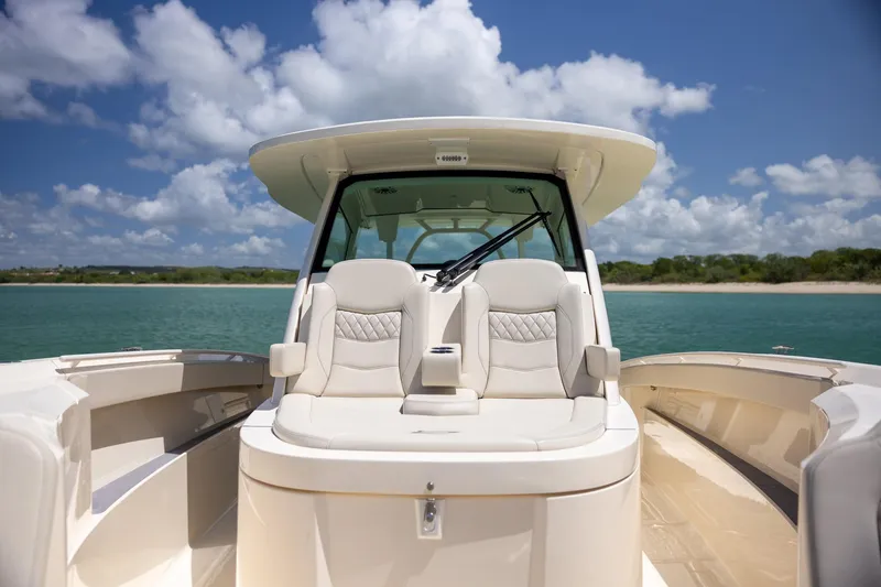 Slide: The Image of 2024 Scout 377 LXF boat interior with luxurious seating, ocean view, and clear sky. - 36