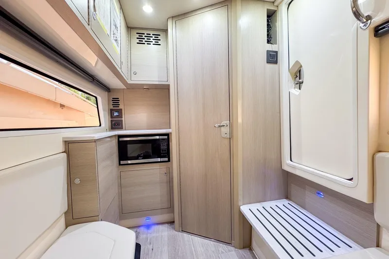 Slide: The Image of 2024 Scout 377 LXF interior with modern cabinetry, microwave, and sleek design. - 40