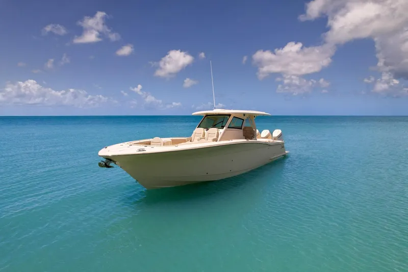 Slide: The Image of 2024 Scout 377 LXF boat on clear blue ocean under a partly cloudy sky. - 5