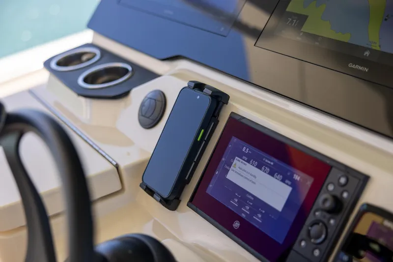 Slide: The Image of 2024 Scout 377 LXF boat dashboard with navigation screens and smartphone holder. - 52