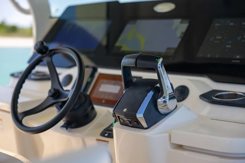 Slide: The Image of 2024 Scout 377 LXF boat helm with steering wheel and control panel. - 53