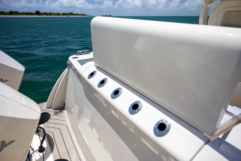 Slide: The Image of 2024 Scout 377 LXF boat with rod holders, ocean view, and clear sky. - 59