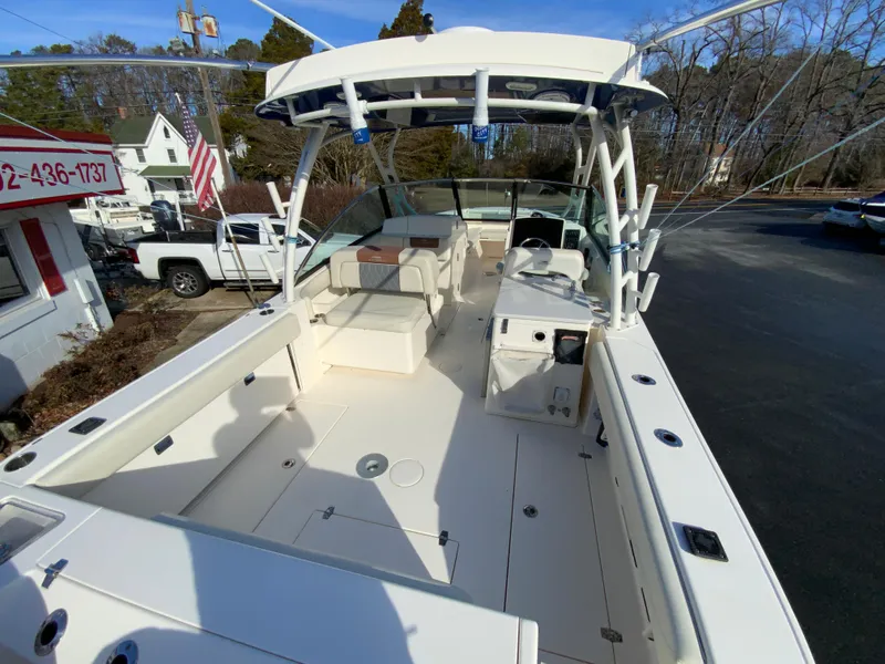 Slide: The Image of 2019 Cobia 280 Dual Console boat with spacious deck and seating, parked outdoors. - 11