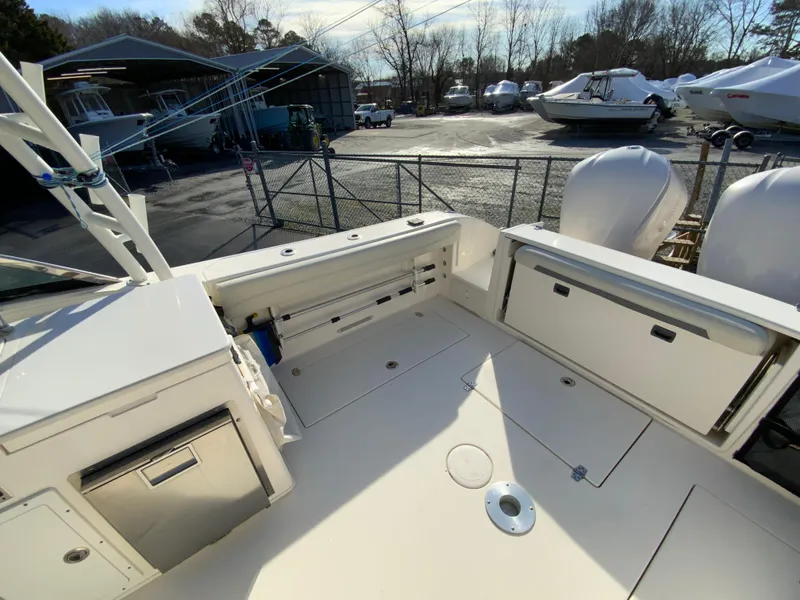 Slide: The Image of 2019 Cobia 280 Dual Console boat deck with storage, docked in a marina. - 13