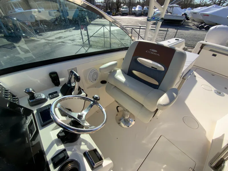 Slide: The Image of 2019 Cobia 280 Dual Console boat interior with steering wheel and captain's chair. - 18