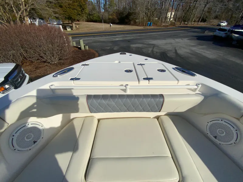 Slide: The Image of 2019 Cobia 280 Dual Console boat interior with cushioned seating and storage compartments. - 21