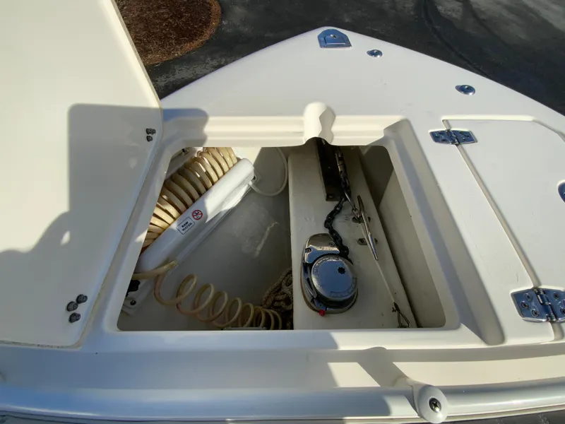 Slide: The Image of 2019 Cobia 280 Dual Console boat storage compartment with coiled hose and equipment. - 22