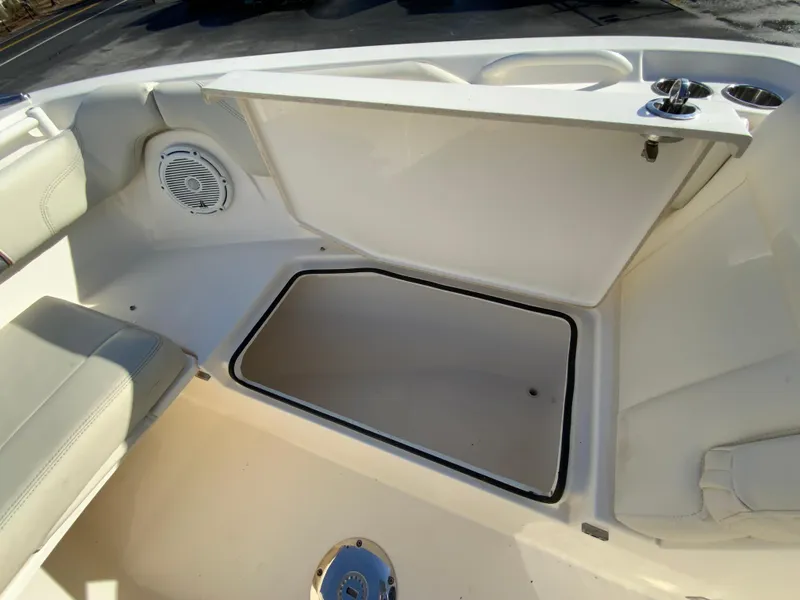 Slide: The Image of 2019 Cobia 280 Dual Console boat interior storage compartment with speaker and cup holders. - 26