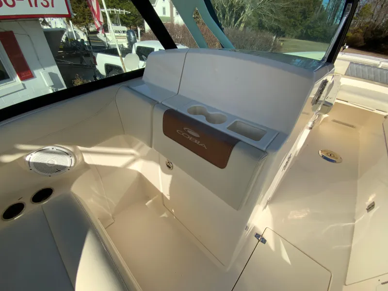Slide: The Image of 2019 Cobia 280 Dual Console boat interior with cup holders and seating area. - 29
