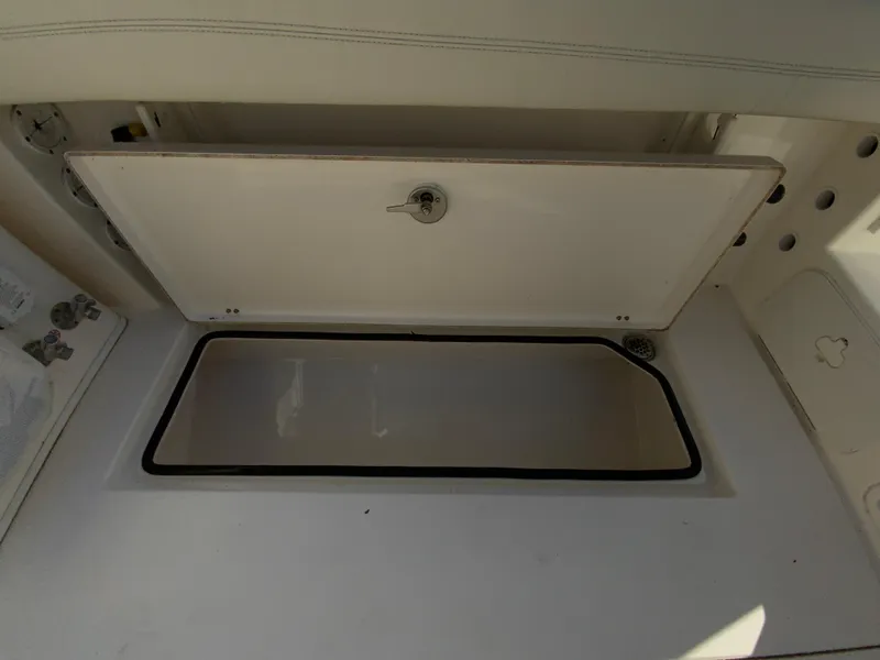 Slide: The Image of Open storage compartment on a 2019 Cobia 280 Dual Console boat. - 36