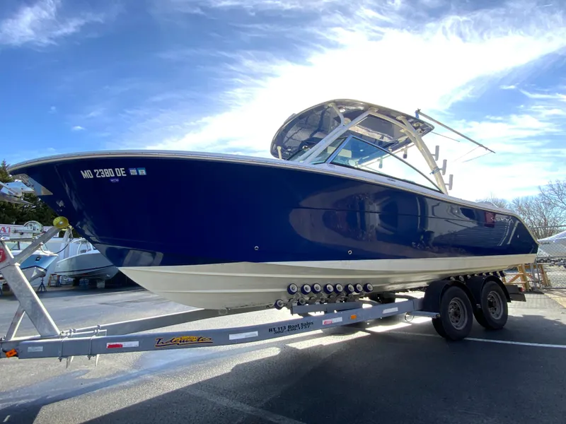Slide: The Image of 2019 Cobia 280 Dual Console boat on trailer under clear sky. - 5