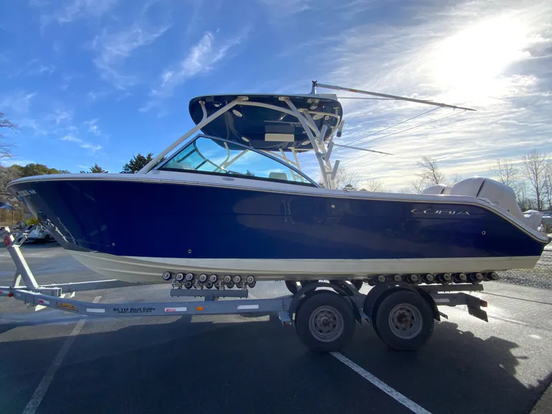 Slide: The Image of 2019 Cobia 280 Dual Console boat on trailer under clear blue sky. - 6