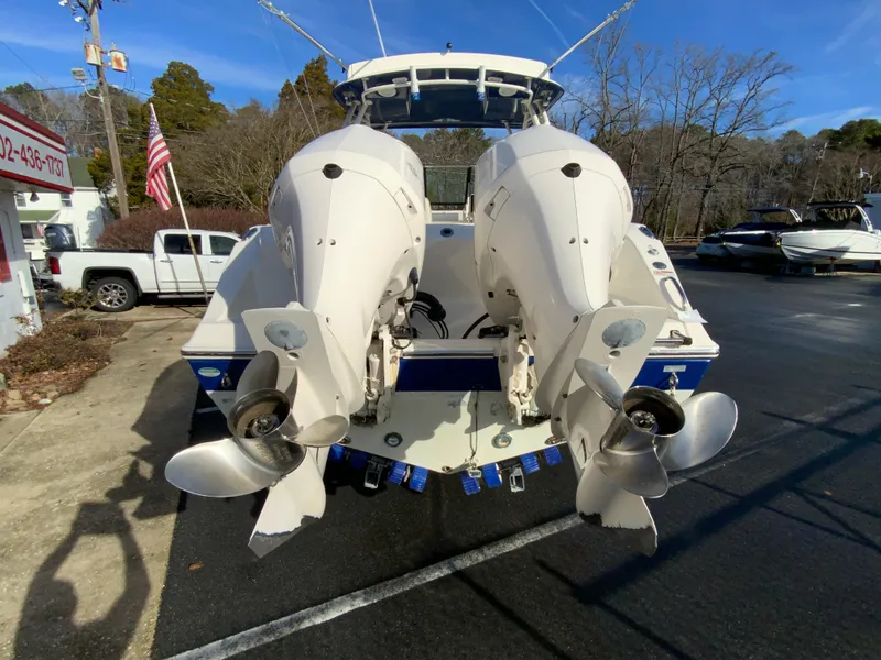 Slide: The Image of 2019 Cobia 280 Dual Console boat with twin outboard engines in a parking lot. - 9
